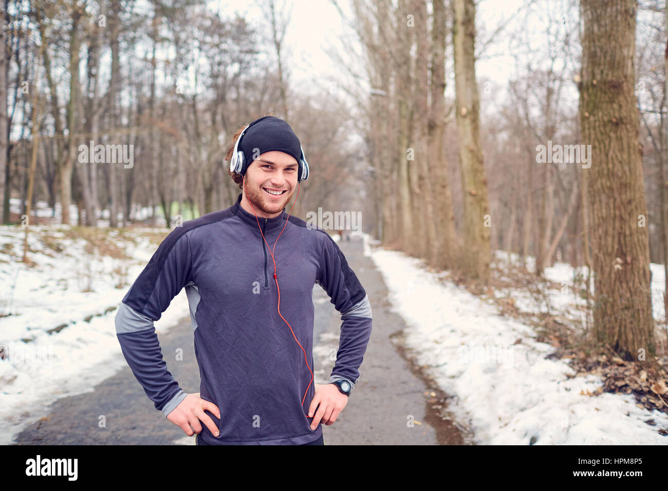 Sports guy in headphones and hat at the park Stock Photo