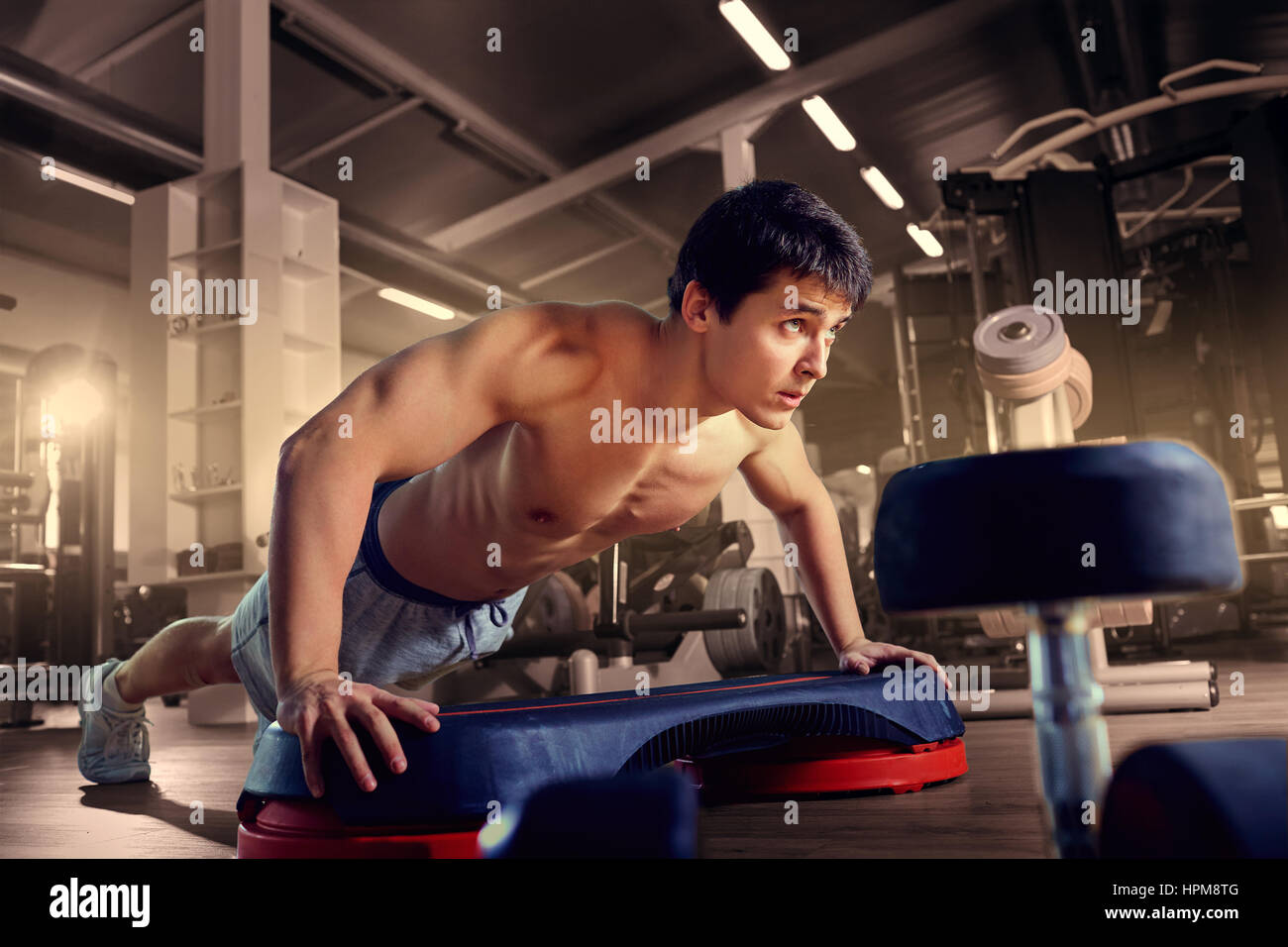 Athletic man is pushed to the floor in the gym Stock Photo