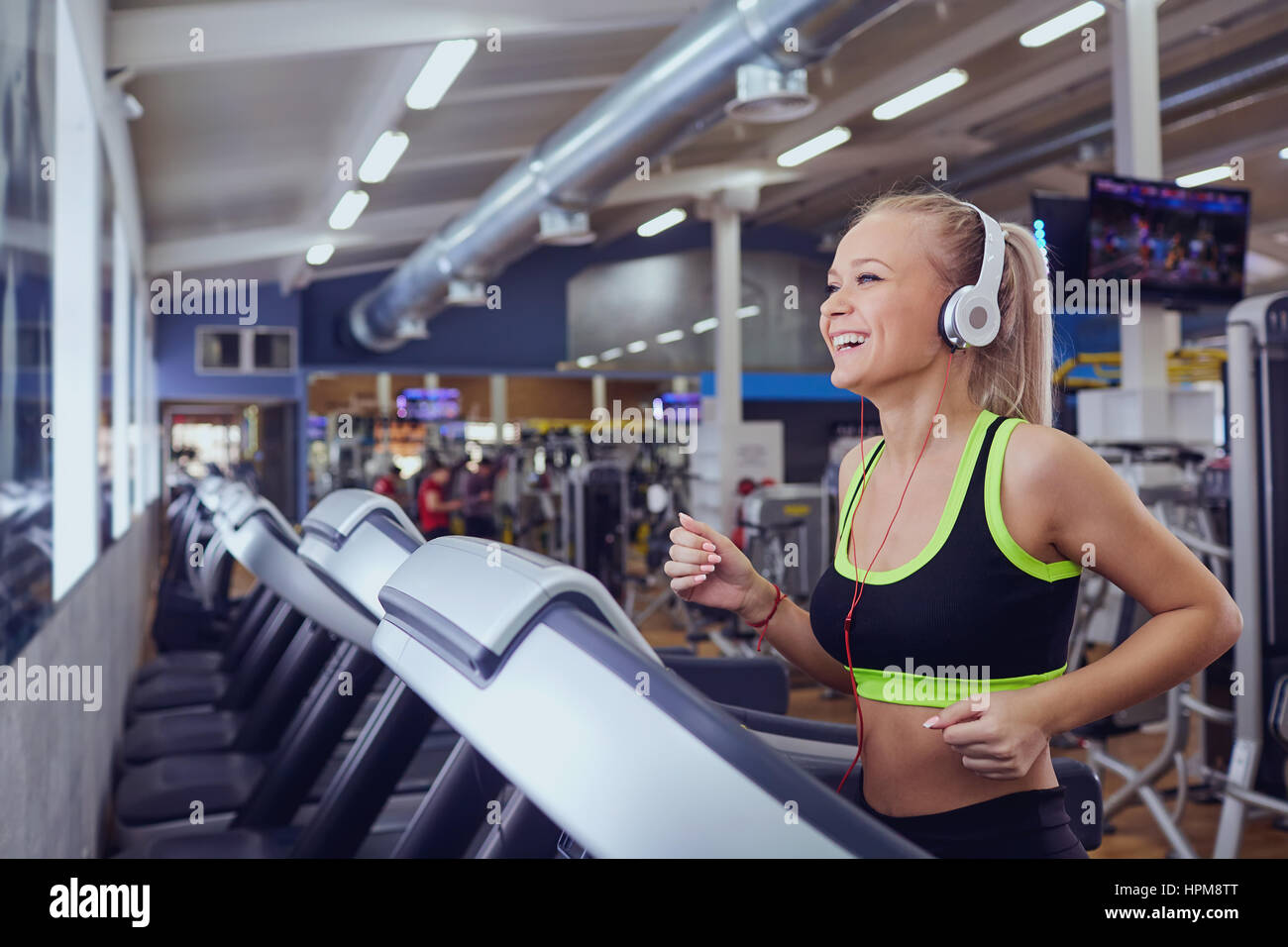 Sport blonde girl smiling happy on the treadmill in the gym Stock Photo ...