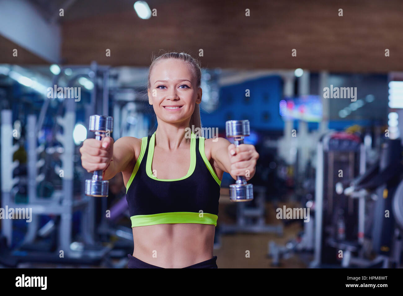 Sports woman with dumbbells in hands  the gym Stock Photo