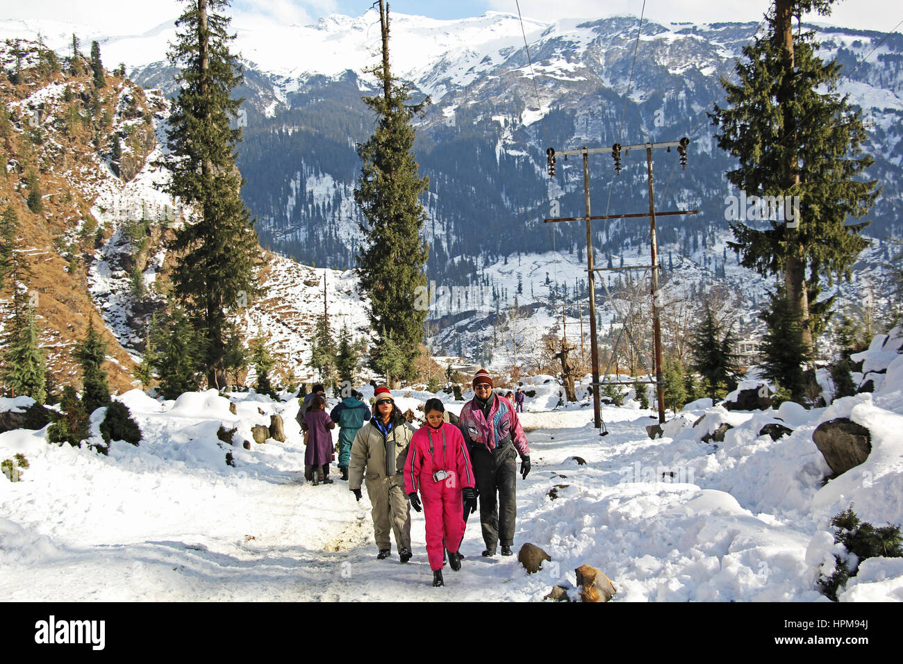 Tourists trekking in snow-clad Himalayan mountain ranges in Manali, India. Stock Photo