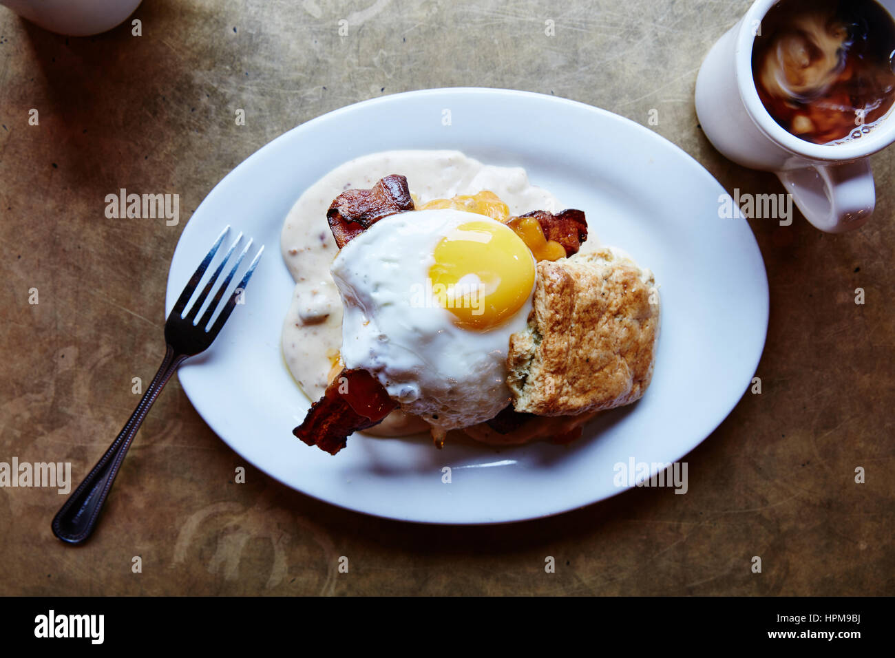 Southern Decadence - Buttermilk biscuit, chicken fried chicken, bacon, cheddar, country sausage gravy, sunny side up egg $13.95 Stock Photo