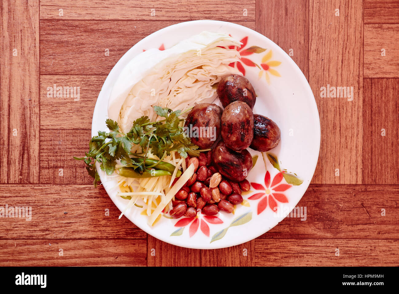 sai krok isaan - isaan sour sausage. sour fermented pork sausage. eat w/ raw cabbage,chile, peanuts.  served a lil pink on the inside $7 Stock Photo