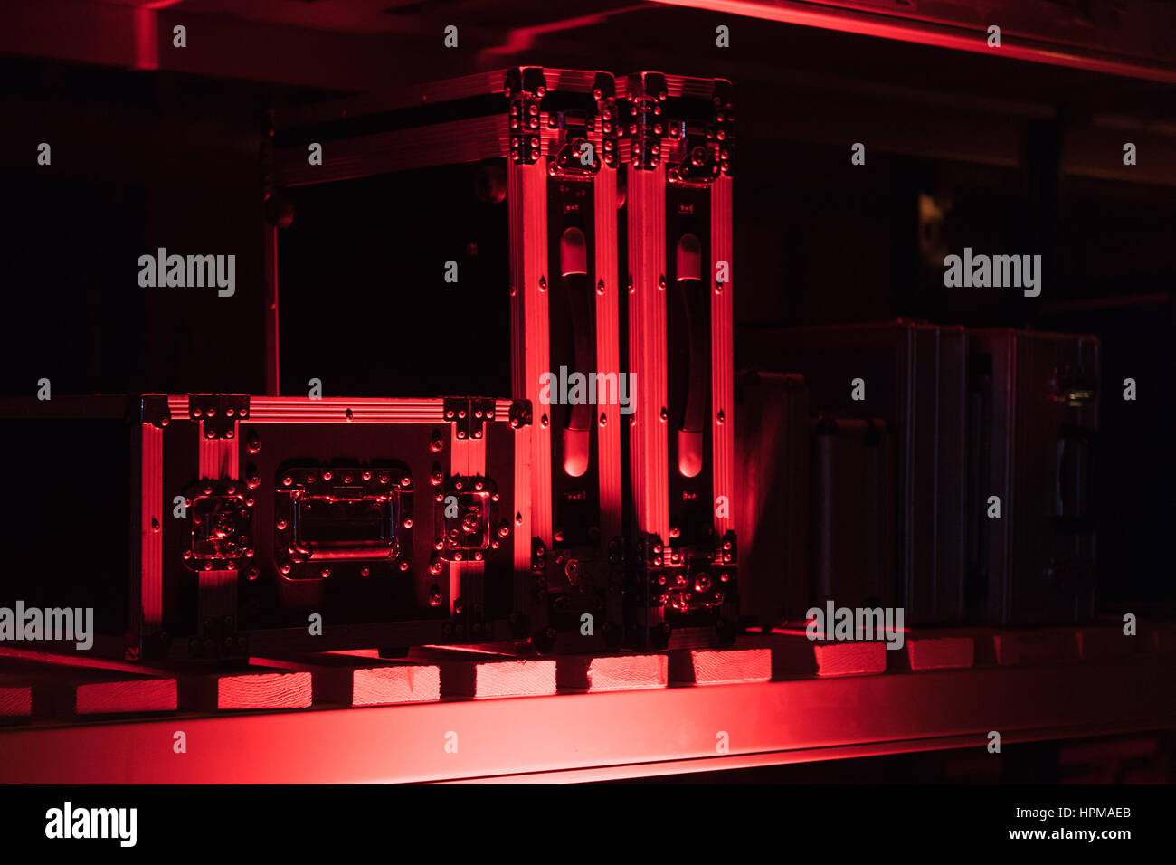 Flight cases for audio visual equipment in storage, lit by event-style uplighting Stock Photo