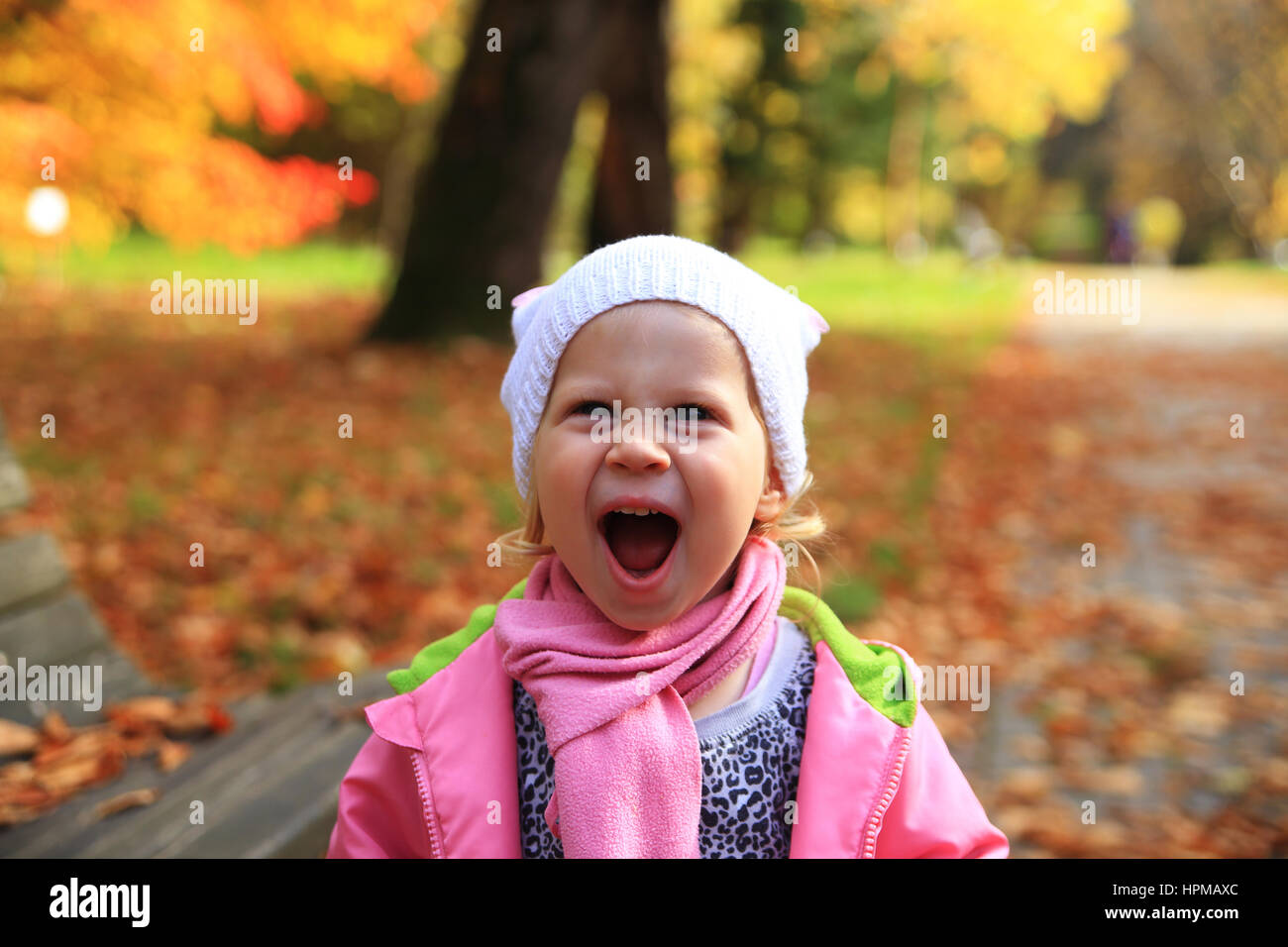 Lifestyle portrait of little happy girl in autumn park Stock Photo - Alamy