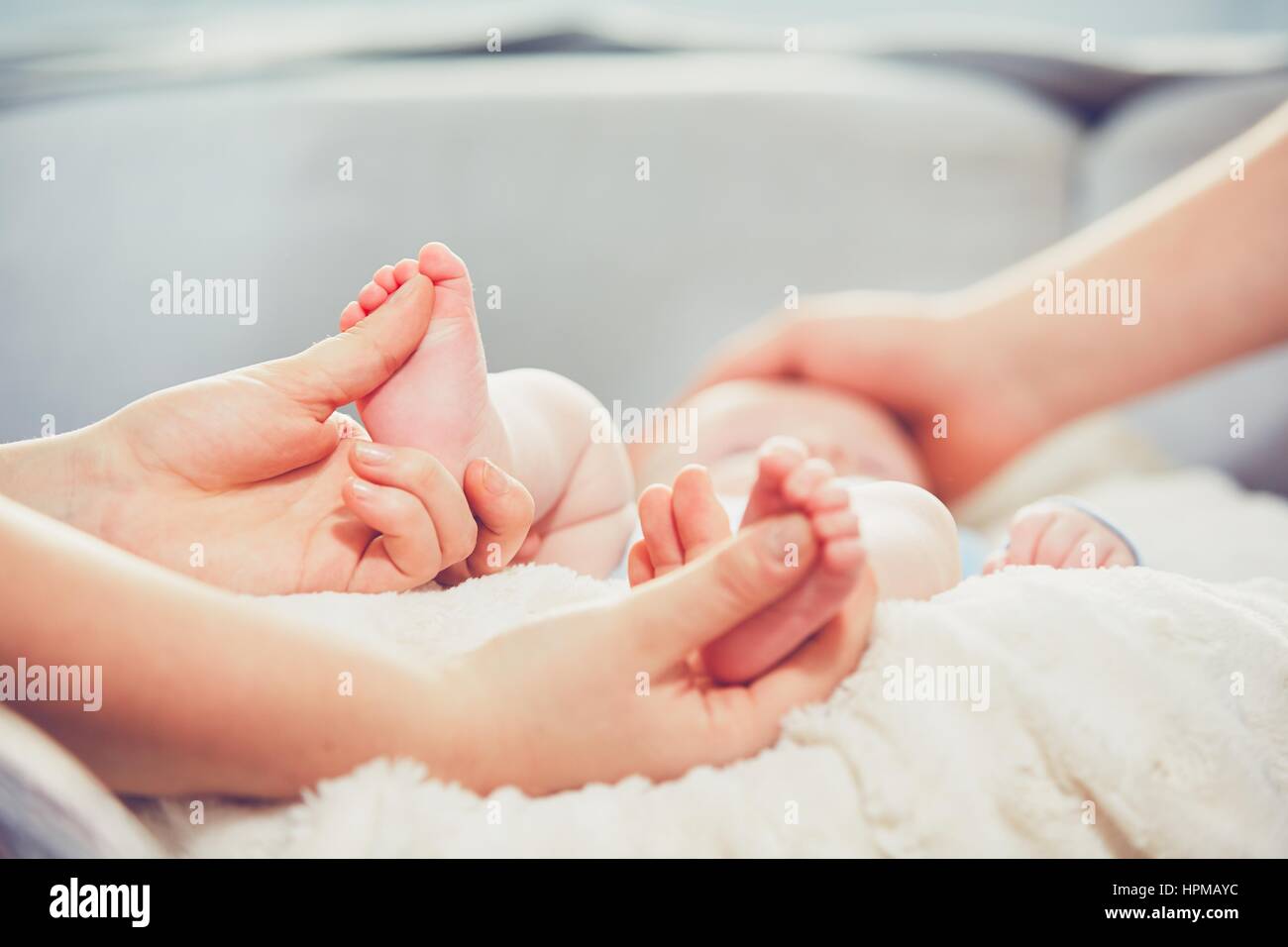Touch of the parent love. Couple caress their little baby in the bed. Stock Photo