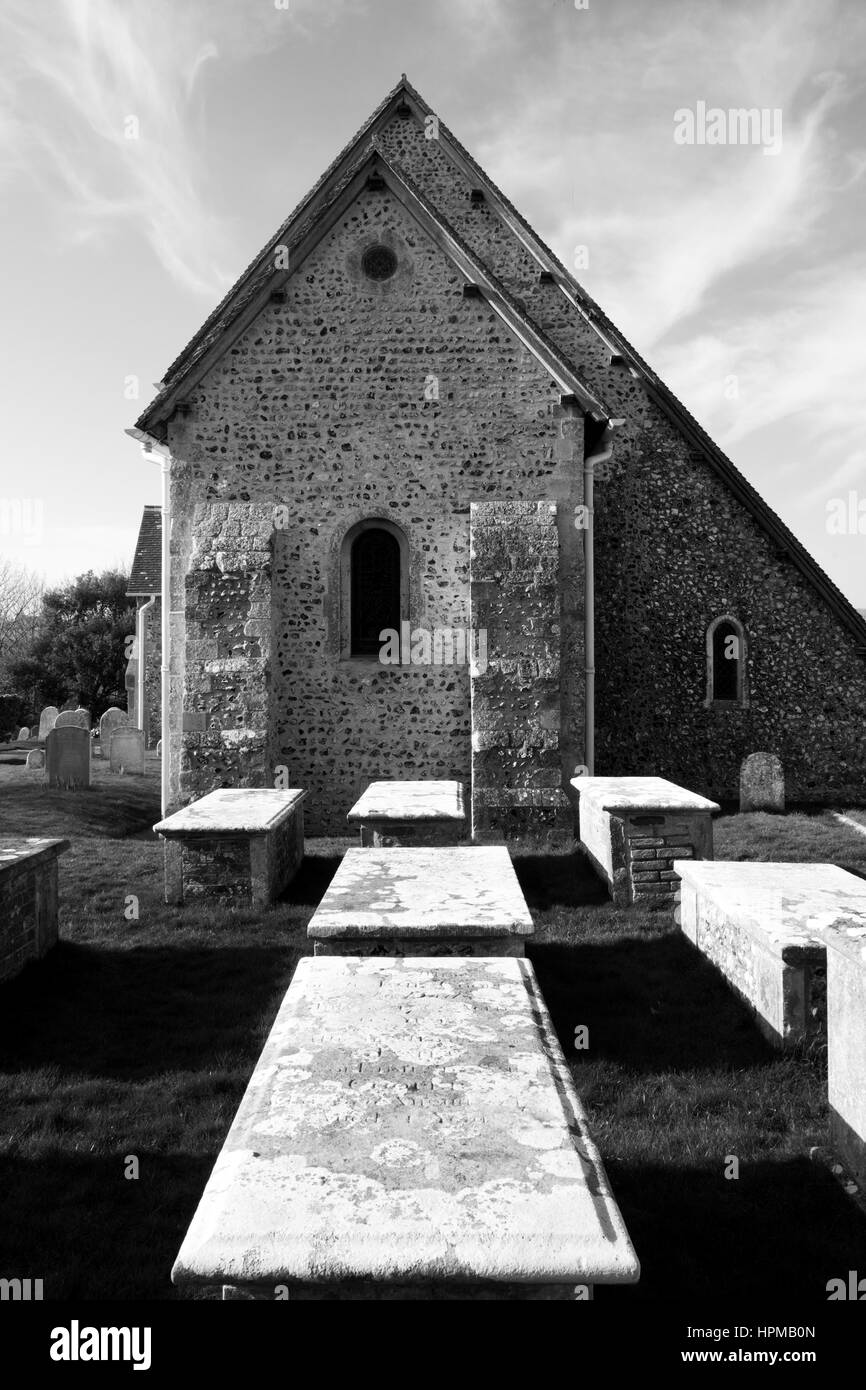 Black and white photograph of Bishopstone village church and grave yard, St Andrew’s church , Bishopstone, united kingdom, the grave tombs are in the Stock Photo
