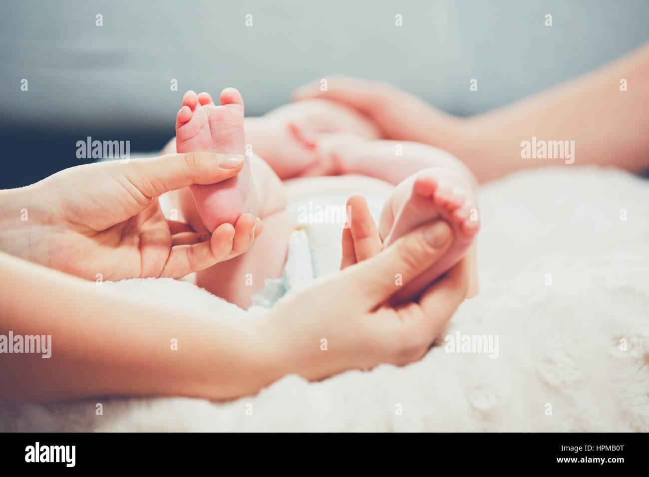 Touch of the parent love. Couple caress their little baby in the bed. Stock Photo