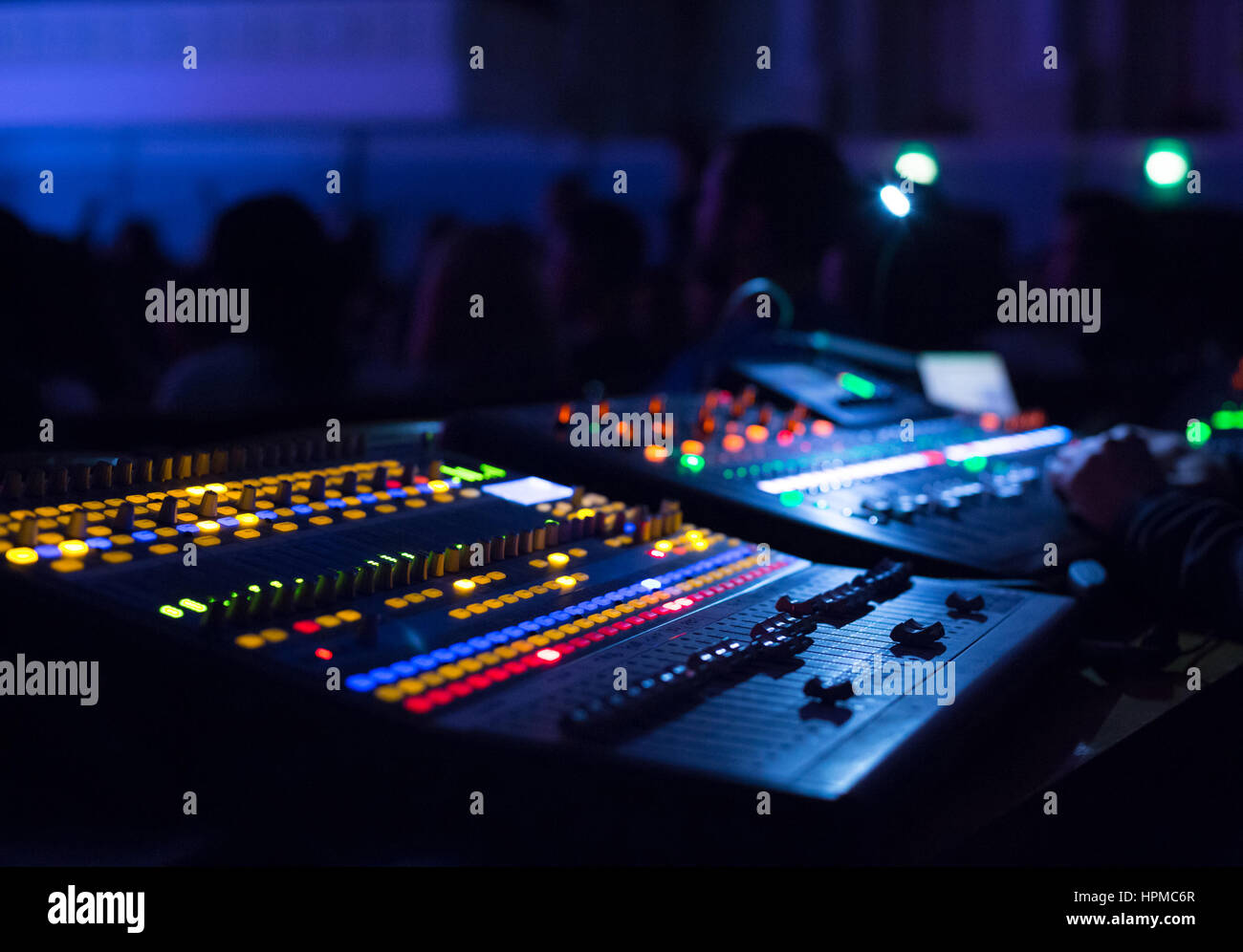 Soundman working on the mixing console in concert hall. Hands on the sliders. Stock Photo