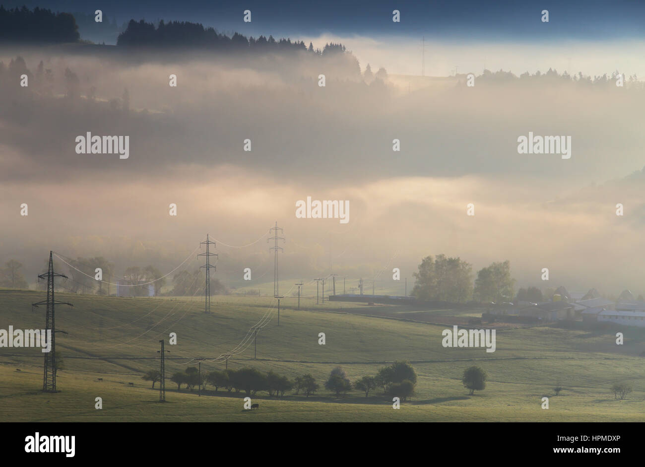 High voltage electric lines on misty mountain hills Stock Photo - Alamy
