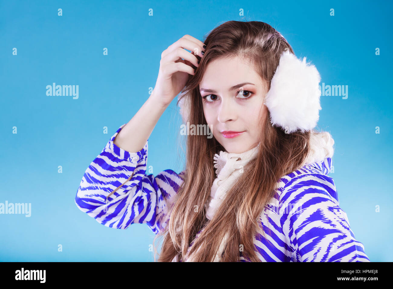Teenage girl wearing fluffy white earmuff in winter fashion, thinking