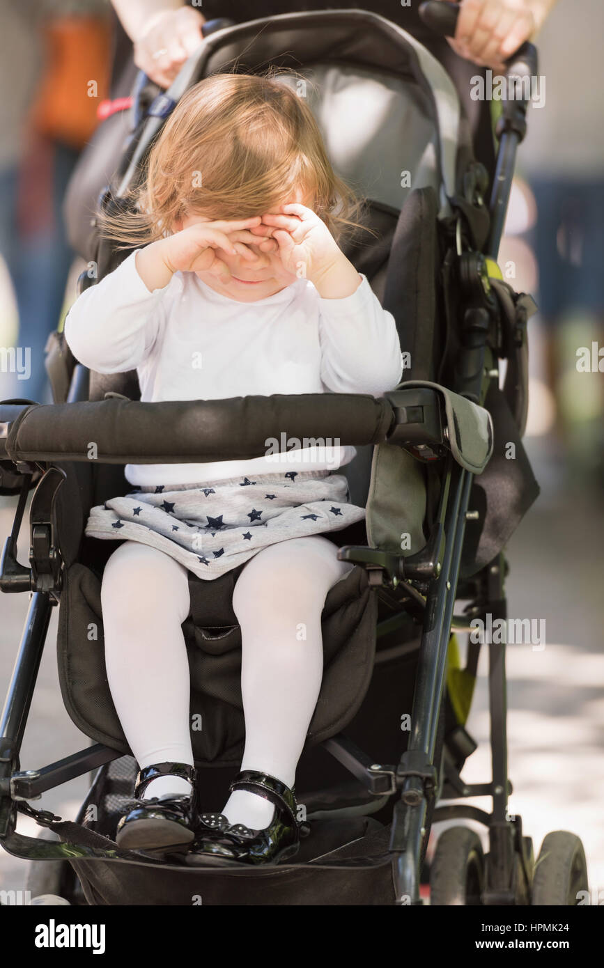 little and very beautiful baby girl sitting in the pram and