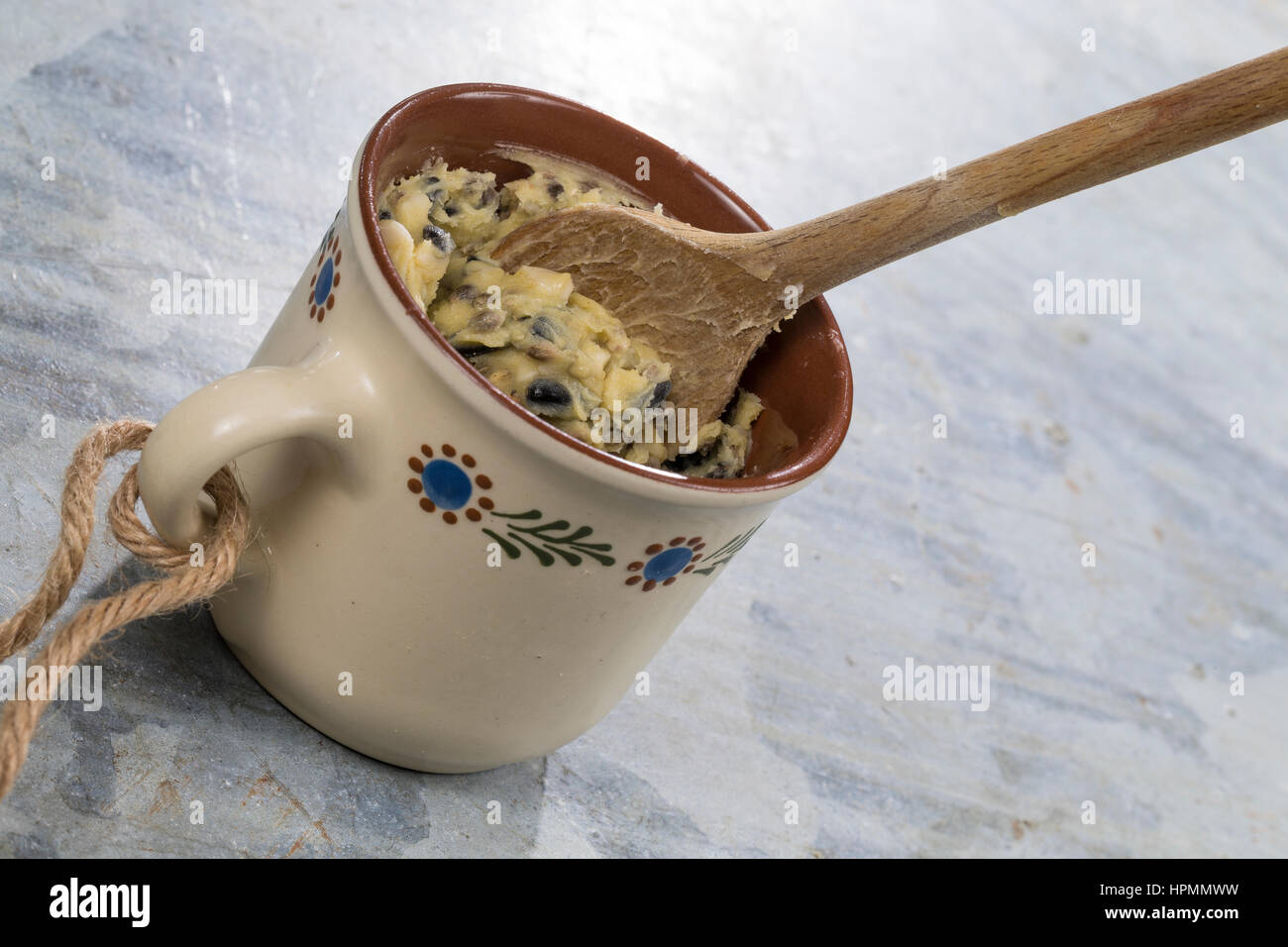 Selbstgemachtes Vogelfutter, Selbstgemachte Fettfuttermischung, wird in Tasse gefüllt, Zutaten Kokosfett, Hanfsamen, Maismehl, Erdnussbruch, Sonnenblu Stock Photo