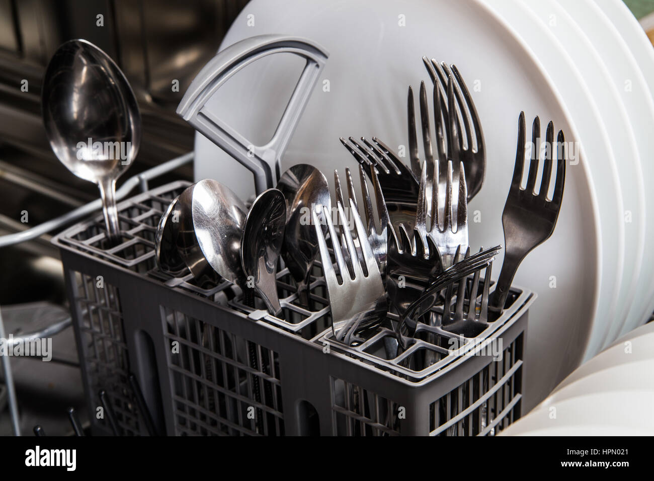 Steel forks and white plates in dishwasher machine Stock Photo