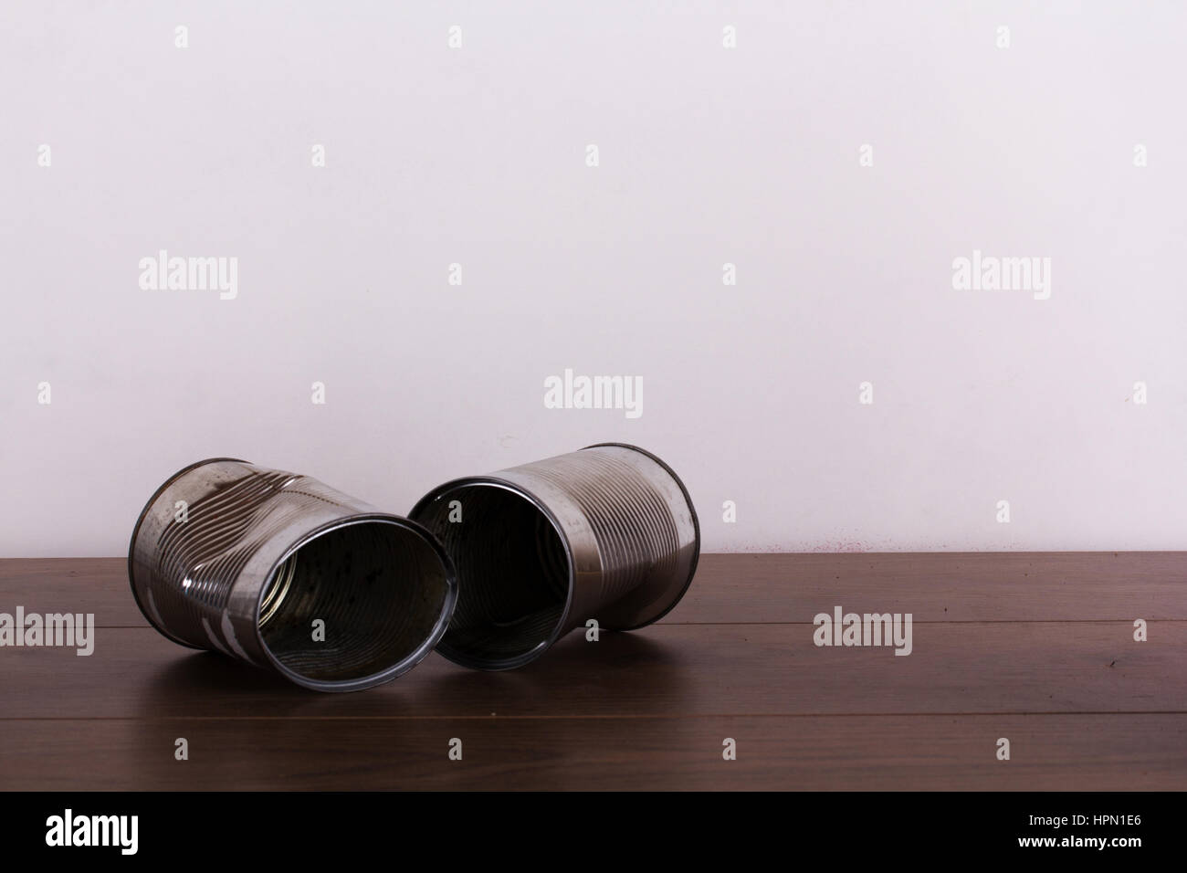 Battered tin cans on a rustic wooden background Stock Photo - Alamy