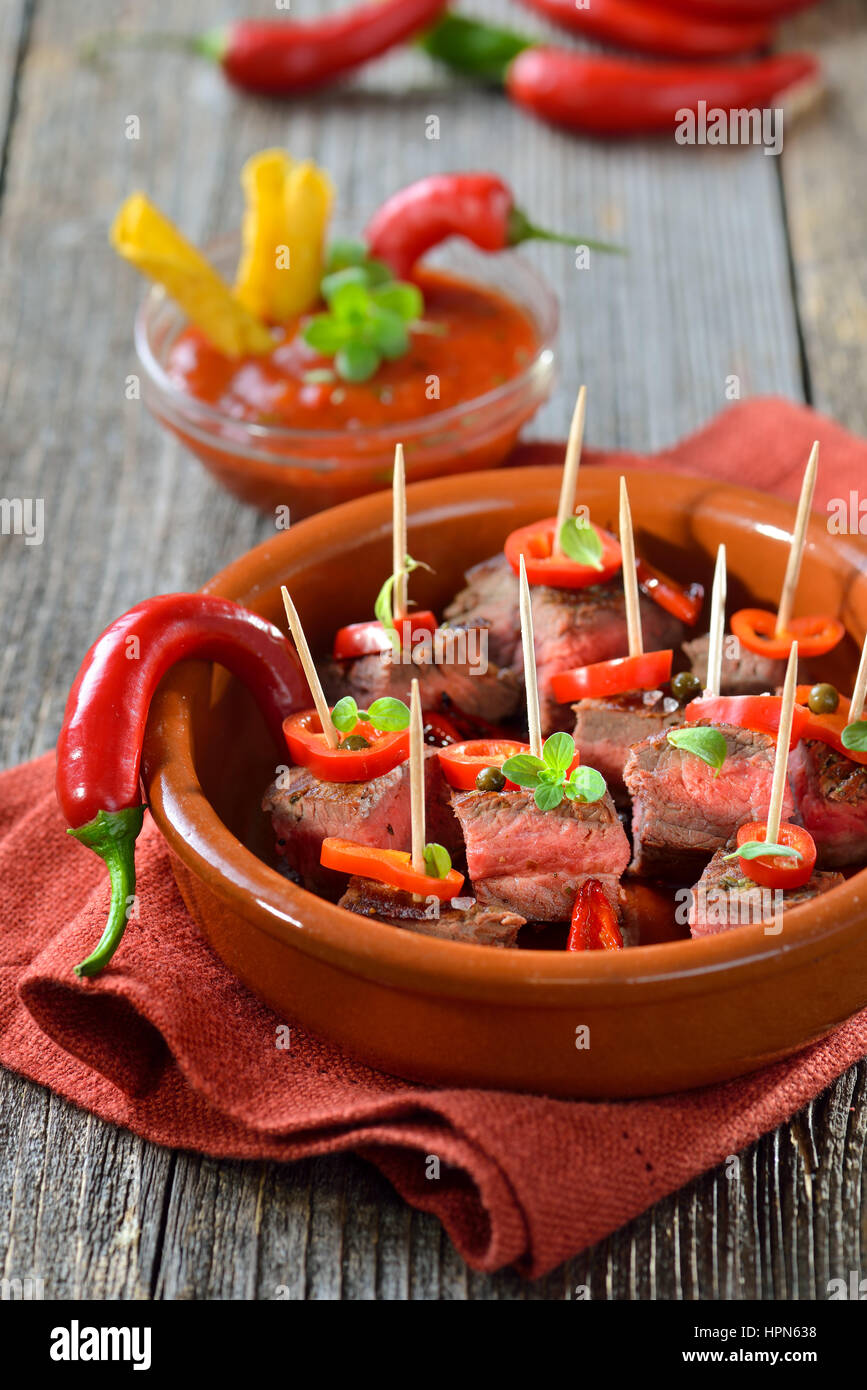 Medium fried steak tapas with chili, peppers and hot dip sauce Stock