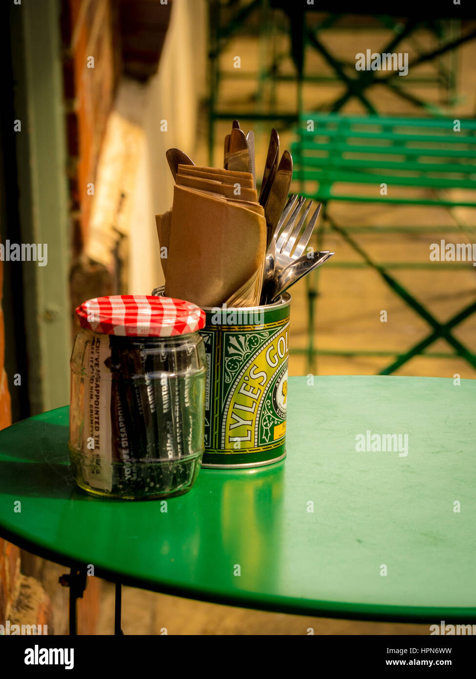 Cutlery, napkins, and sugar in jars and cans on  outdoor cafe bistro style table, Thirsk, North Yorkshire, UK. Stock Photo