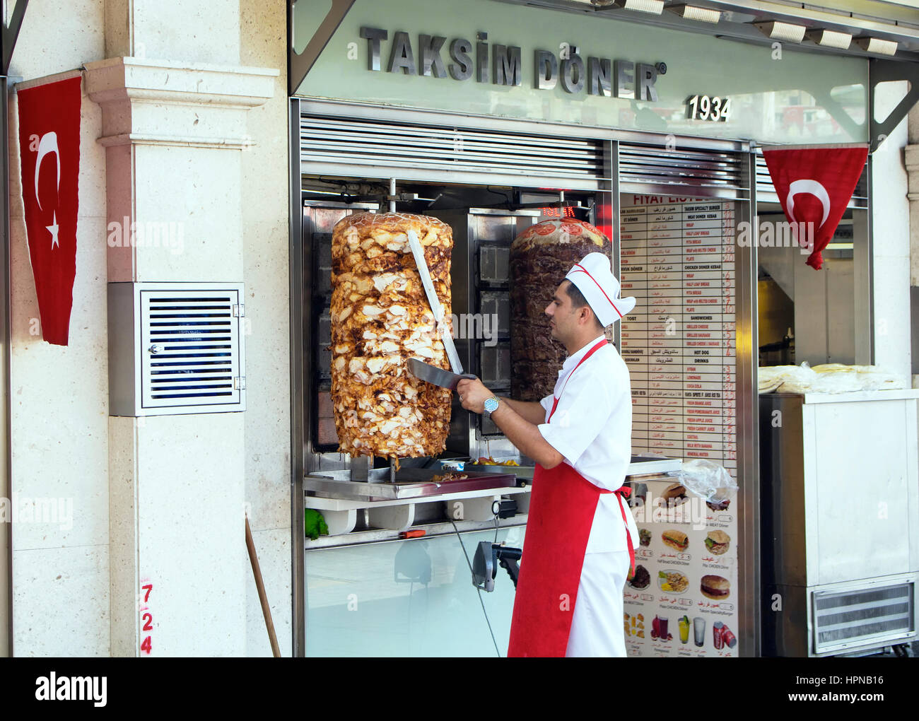 Turkish man cuts chicken doner kebap place in the begining of Istiklal and Siraselviler avenues at Taksim square. Stock Photo