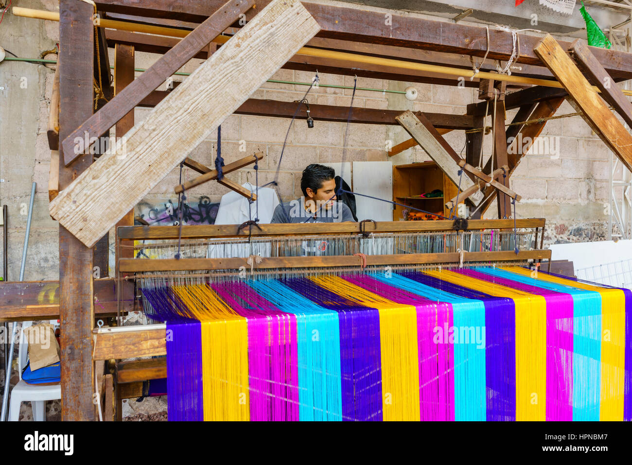 Teotihuacan, FEB 17: Man weaving cotton in an old traditioan machine on FEB 17, 2017 at Teotihuacan, Mexico Stock Photo