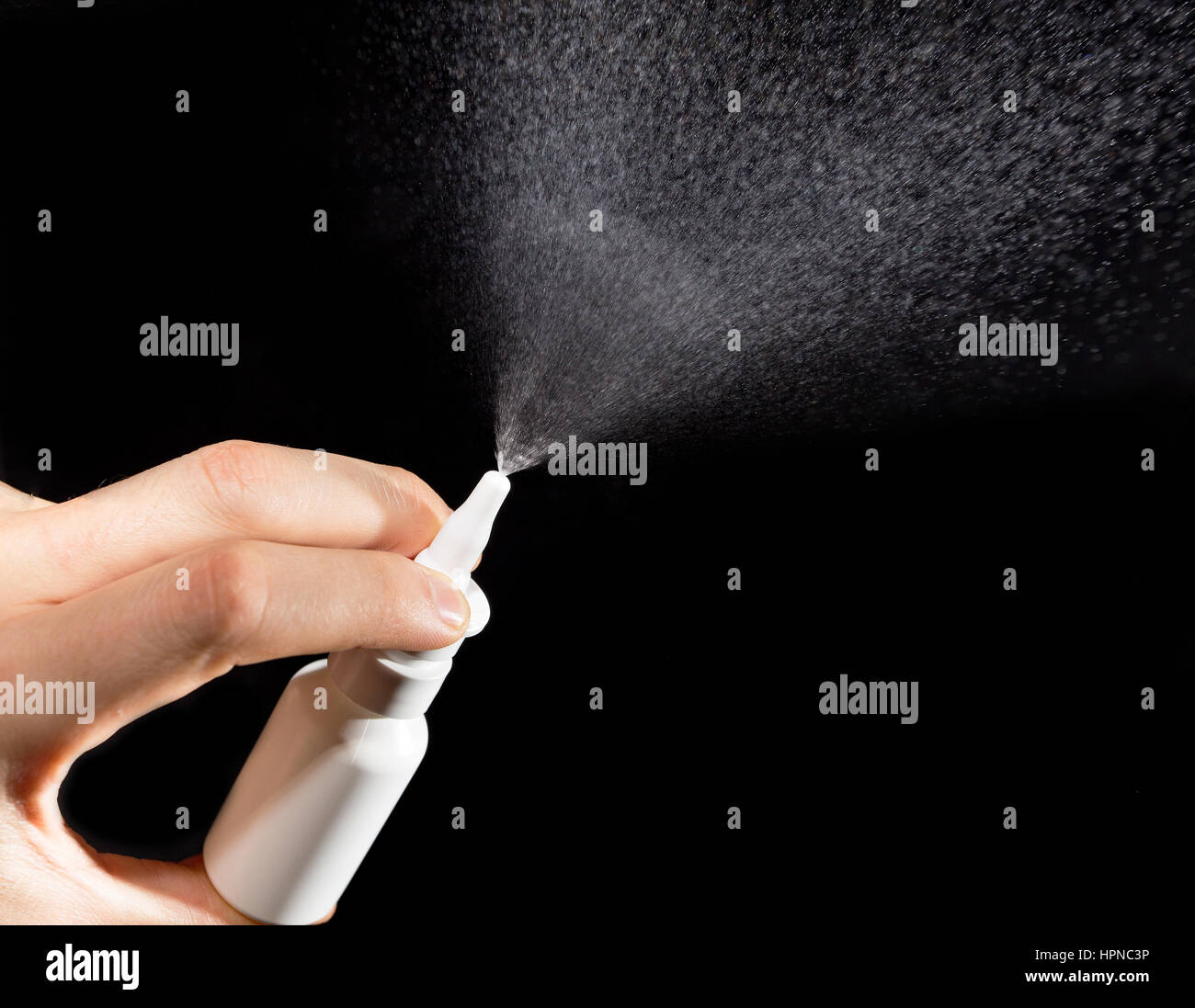 Close-up of nasal drug spraying in hand on black background Stock Photo