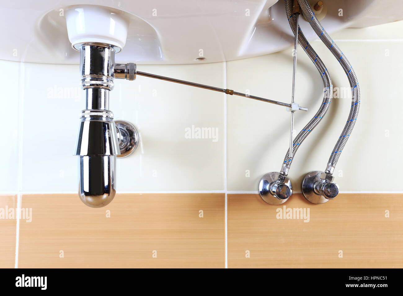 Clean washbasin sink . Chrome pipes and valves. Bright bathroom background. Stock Photo