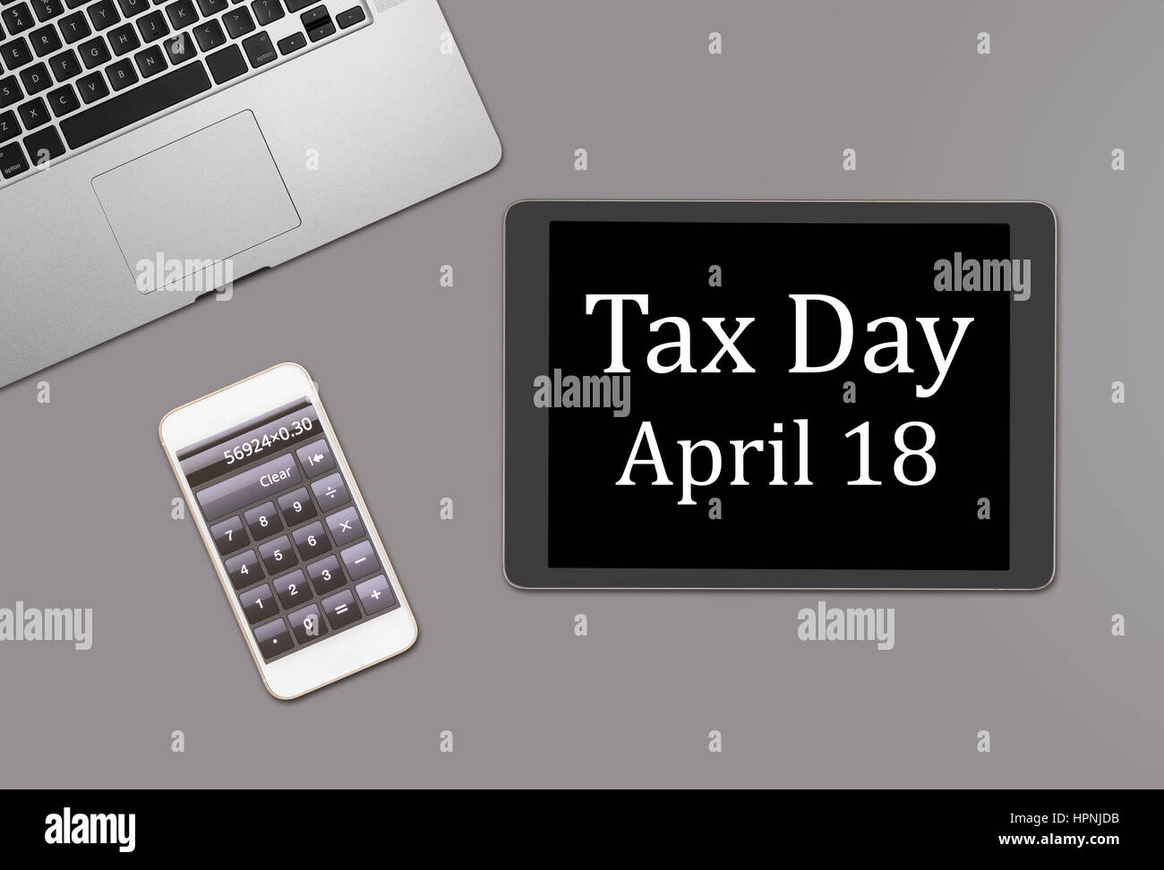 Overhead clean desk for laptop, smartphone and tablet computer with message for tax day 2017 as April 18 Stock Photo