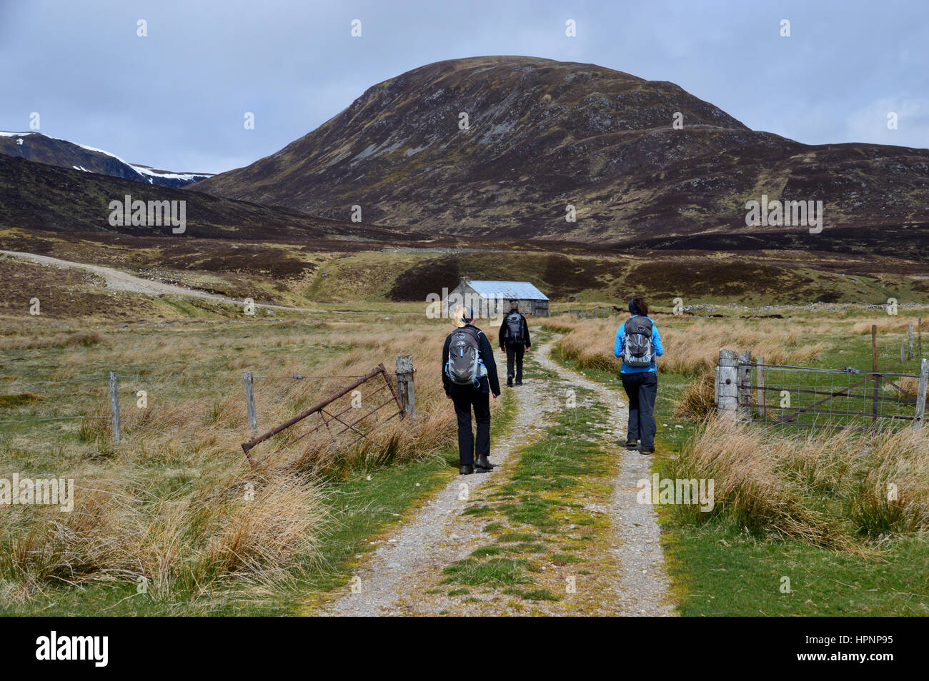 Three Hikers Walking Towards Dalnashallag Bothy in Glen Banchor on the