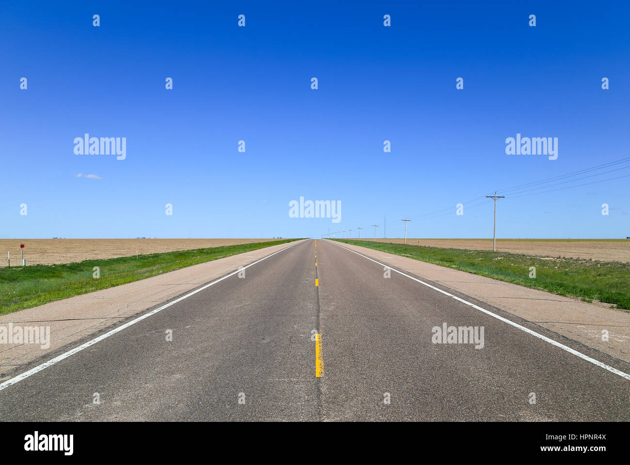 Highway between fields near Lakin in Kansas, USA, with transmission