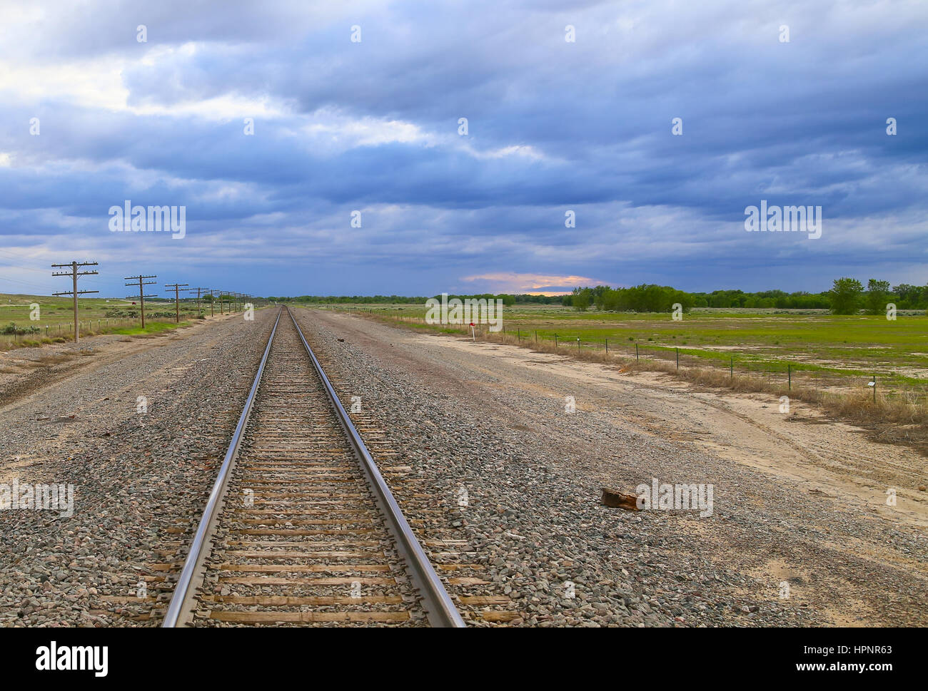Railroad tracks with transmission lines to the one side and an ...