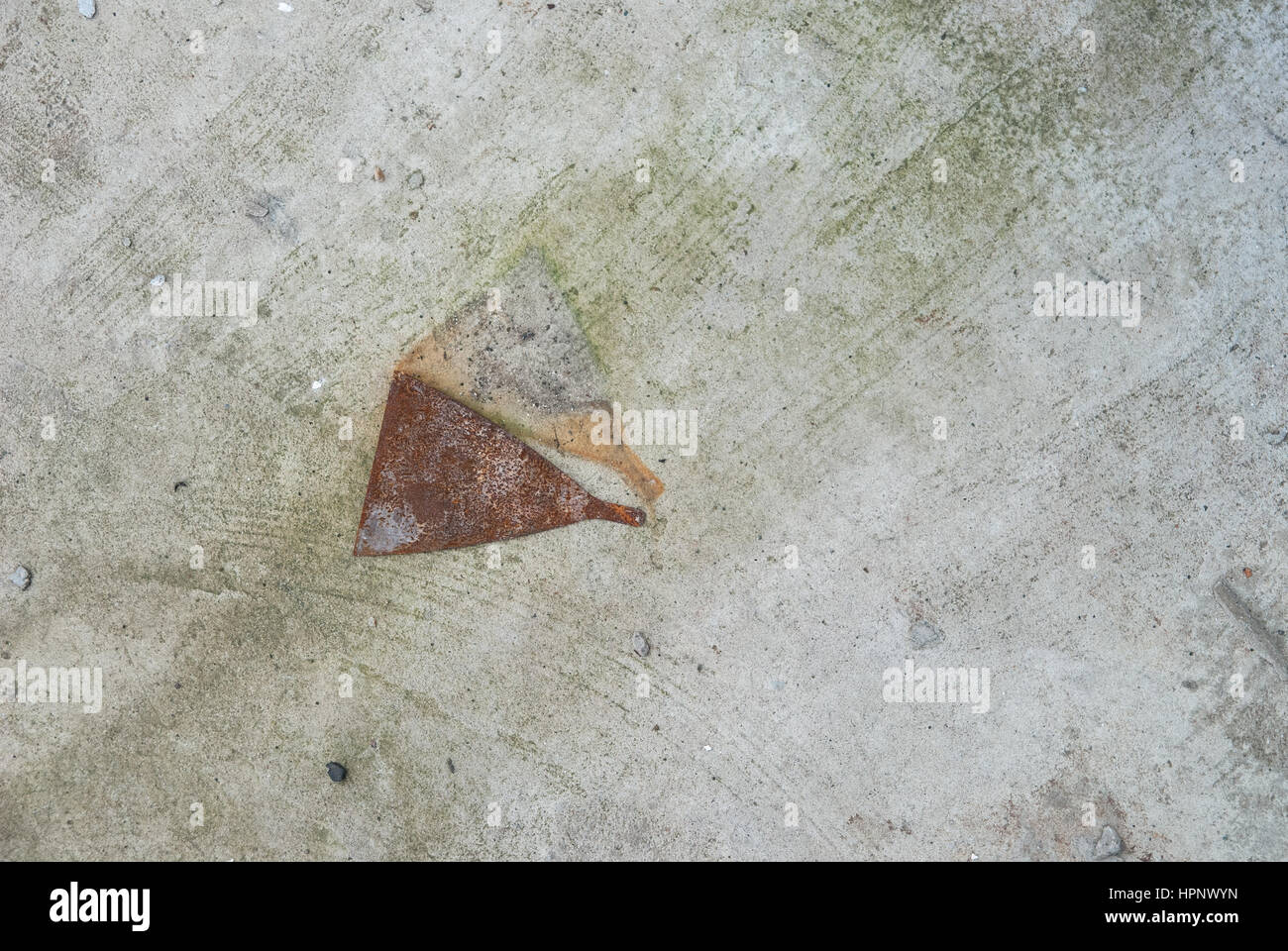Photo of grey concrete wall with the rust metal tool for texture