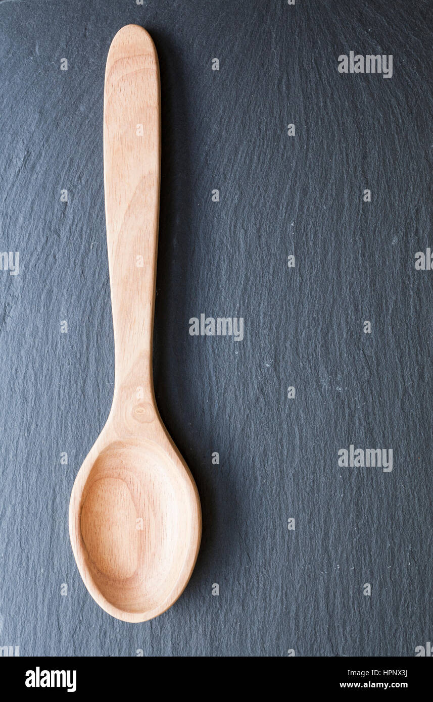 Wooden serving spoon on dark slate Stock Photo
