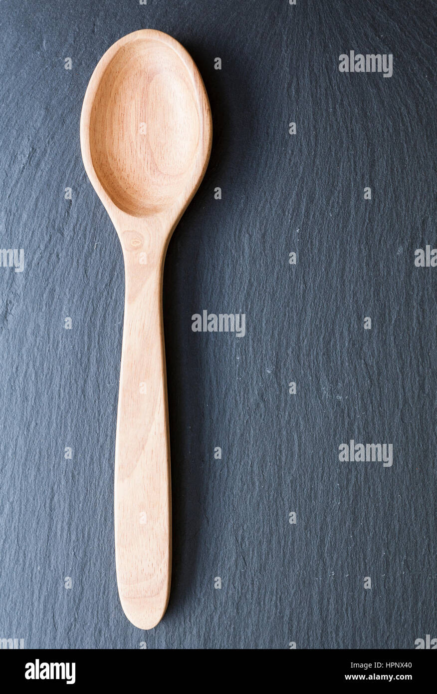 Wooden serving spoon on dark slate Stock Photo
