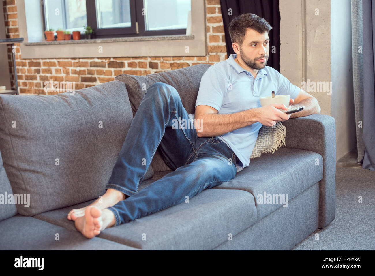 man watching movie while eating breakfast Stock Photo Alamy