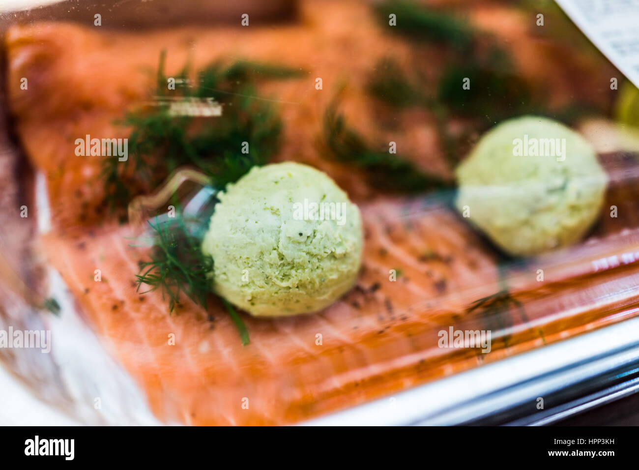 Raw salmon filets with pesto butter in packaged plastic container Stock Photo
