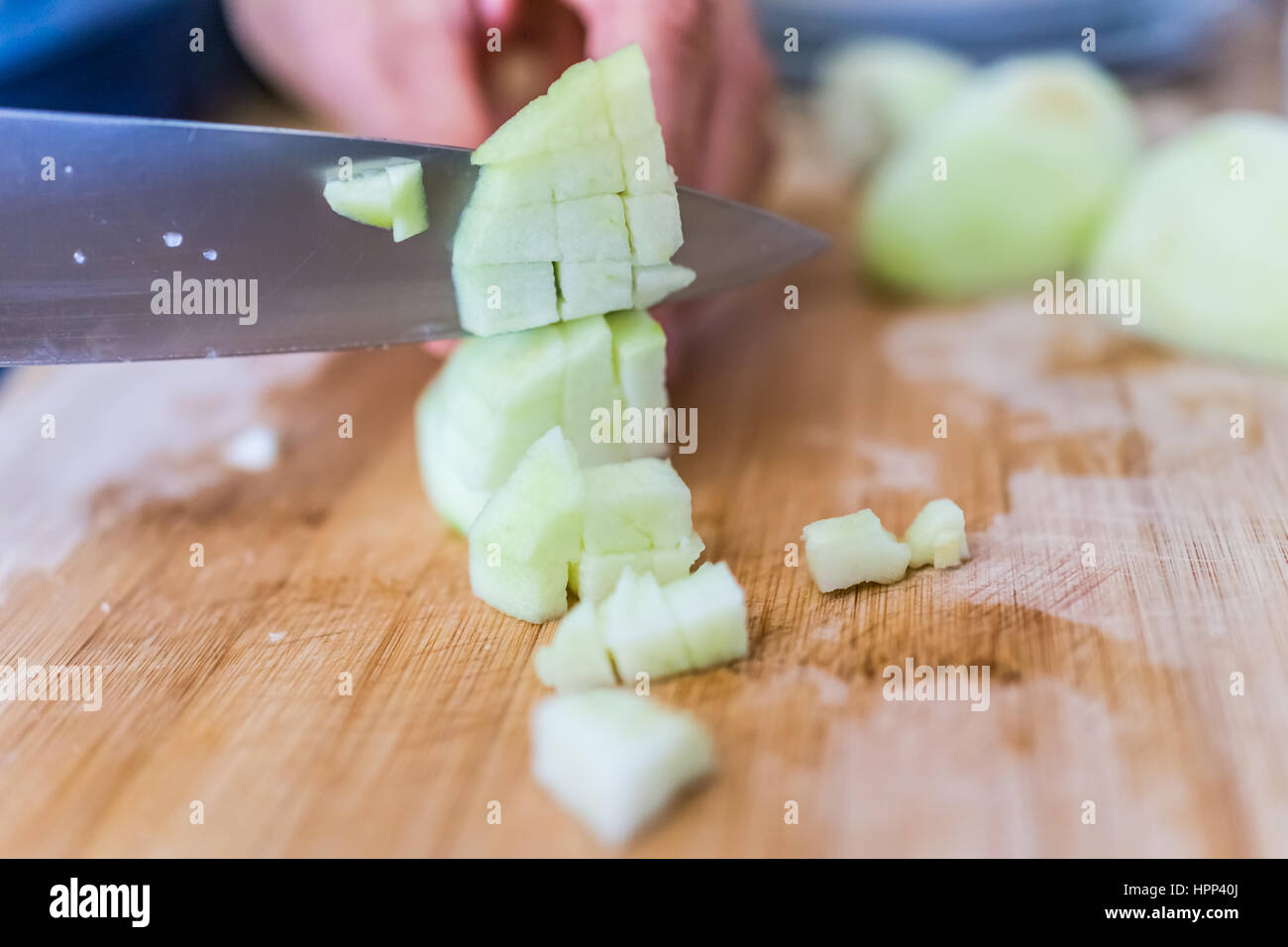 Cook chopping green peeled granny smith apples on board with large