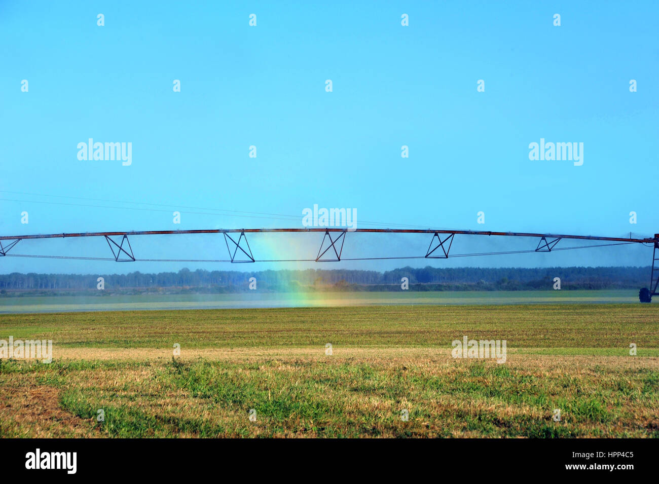 Rainbow forms in irrigation system in field in Southern Arkansas.  Rainbow could symbolize hope for the future of agriculture. Stock Photo