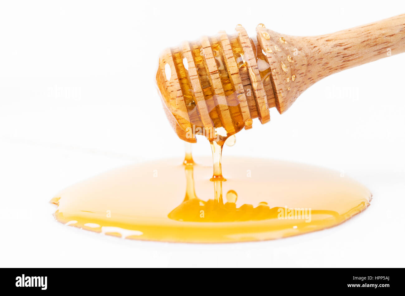Honey dripping with honey stick isolated on a white background Stock
