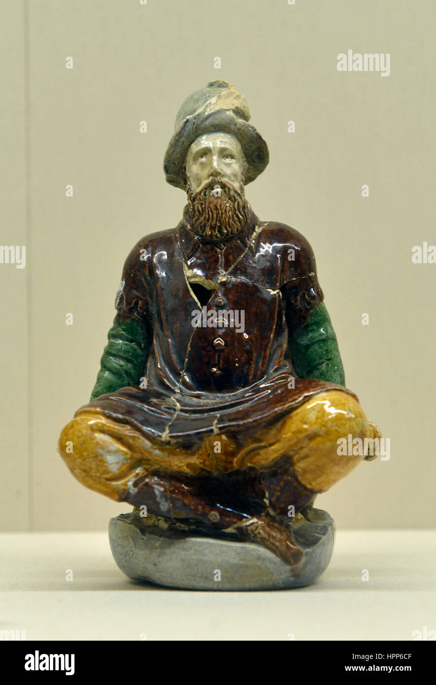 Glazed pottery man cross his legs in Louvre. Ateliers d’Adon Stock