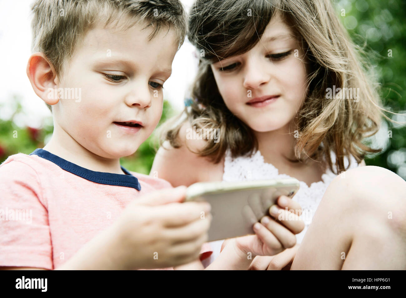 Brother and sister using smart phone Stock Photo - Alamy