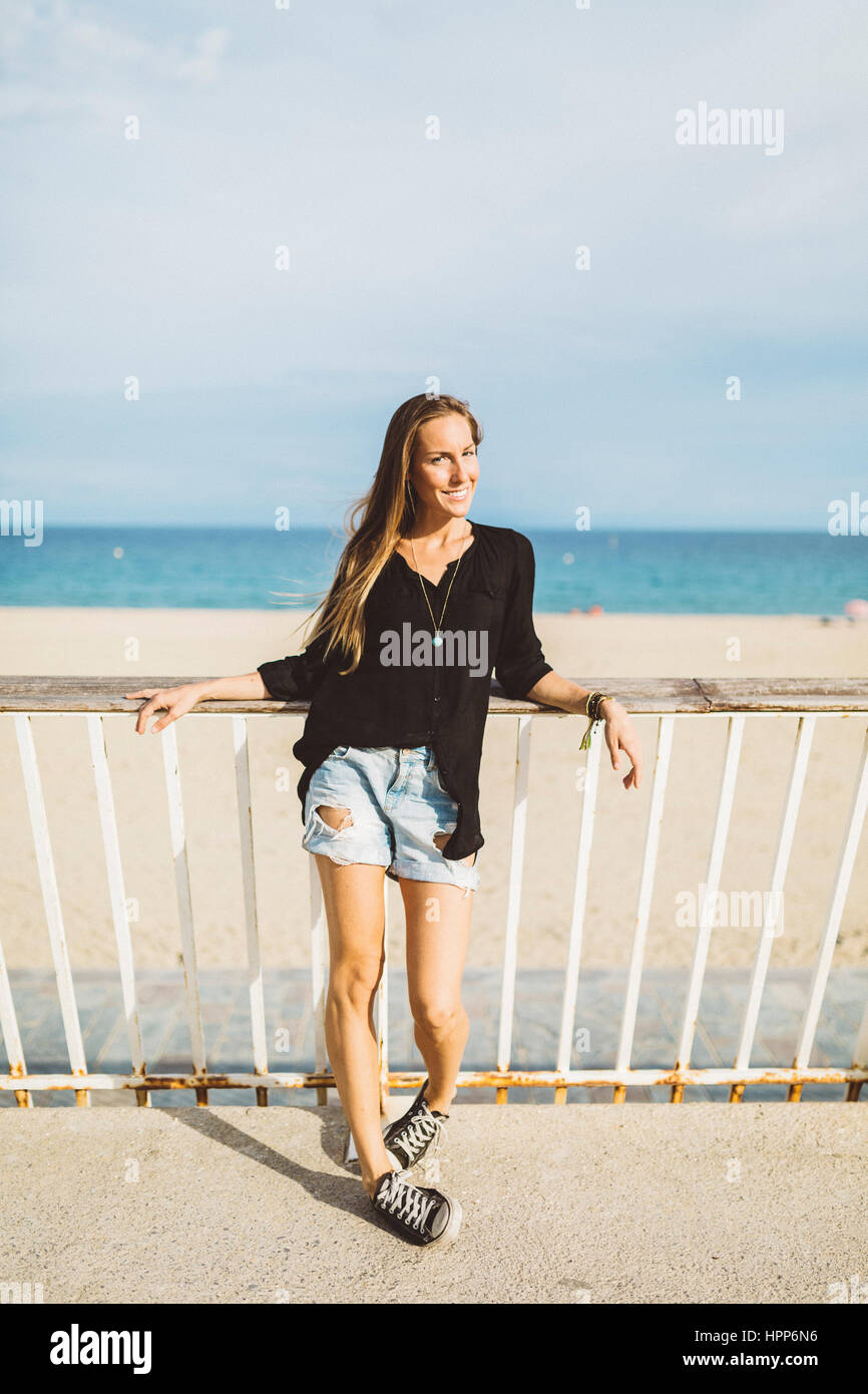 Portrait of smiling young woman at the beach Stock Photo - Alamy