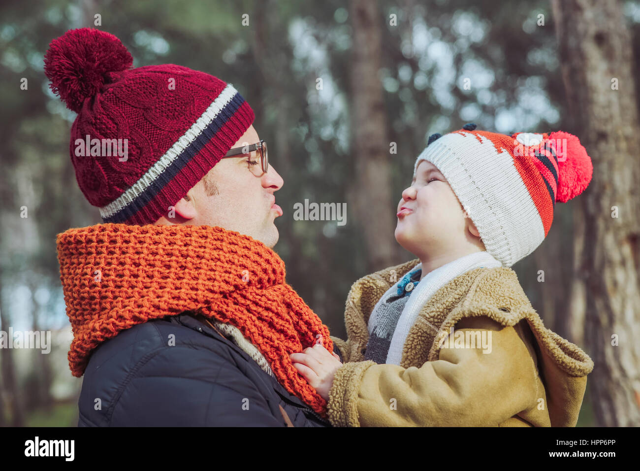 Father and son making funny faces in forest Stock Photo