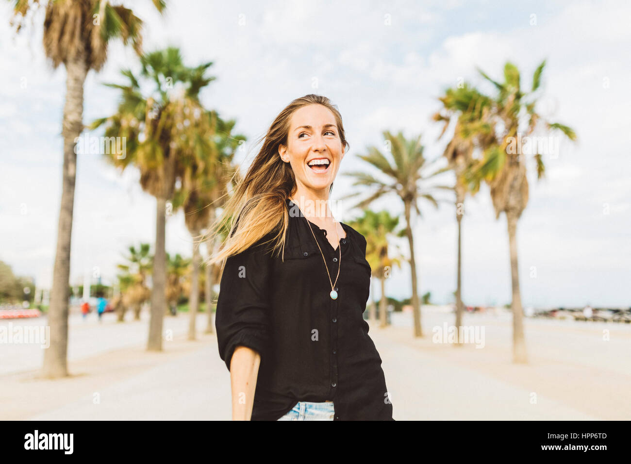 Happy young woman on waterfront promenade Stock Photo - Alamy