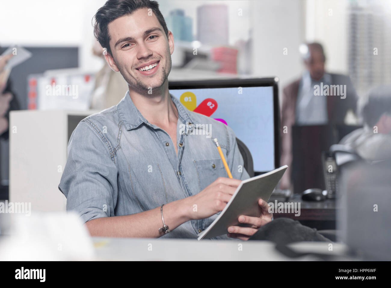 Portrait of smiling young man at office desk Stock Photo - Alamy