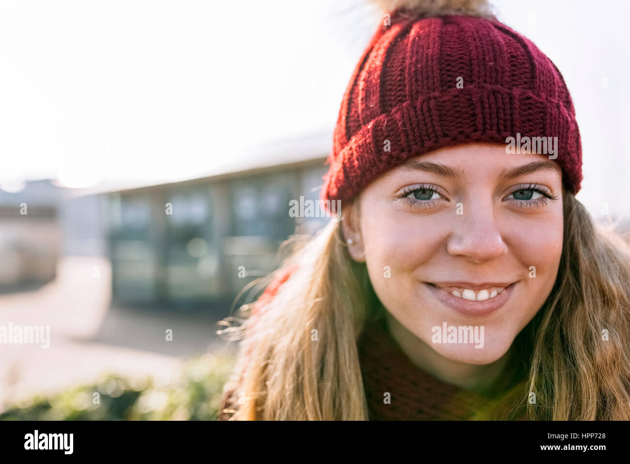 Portrait of smiling teenage girl wearing woolly hat Stock Photo - Alamy