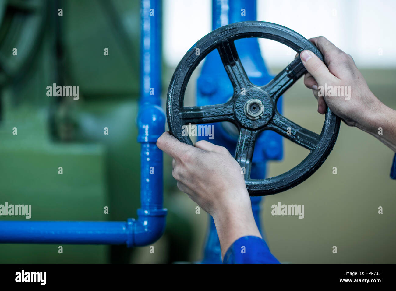 Hands turning valve in factory Stock Photo