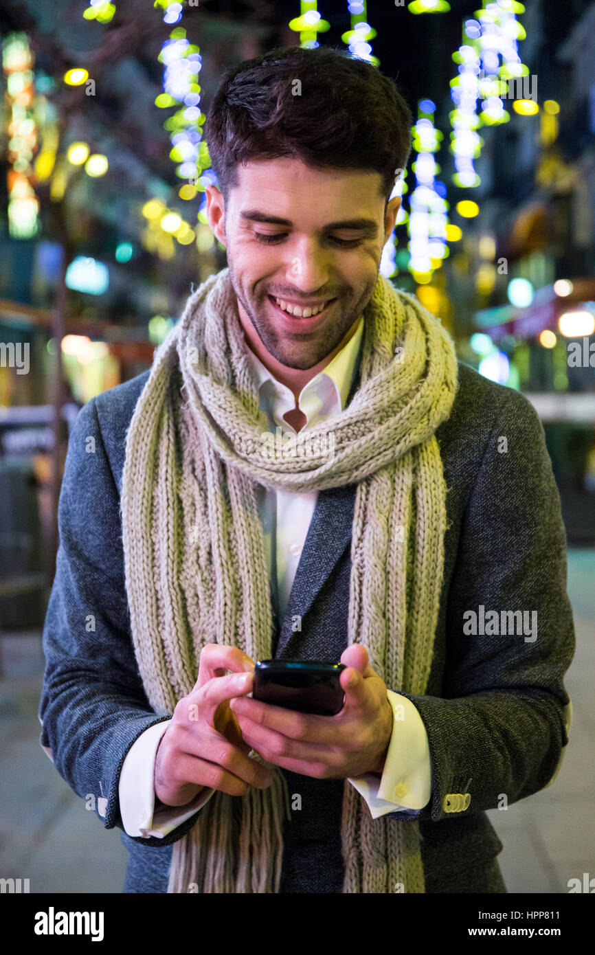 Man using his cell phone in the city at night Stock Photo