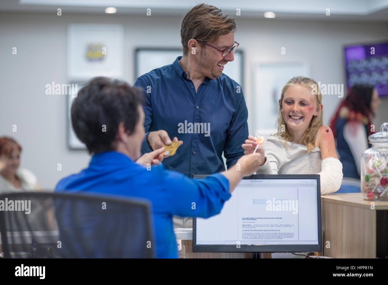 Sick girl getting lollipop from receptionist in hosptal Stock Photo Alamy
