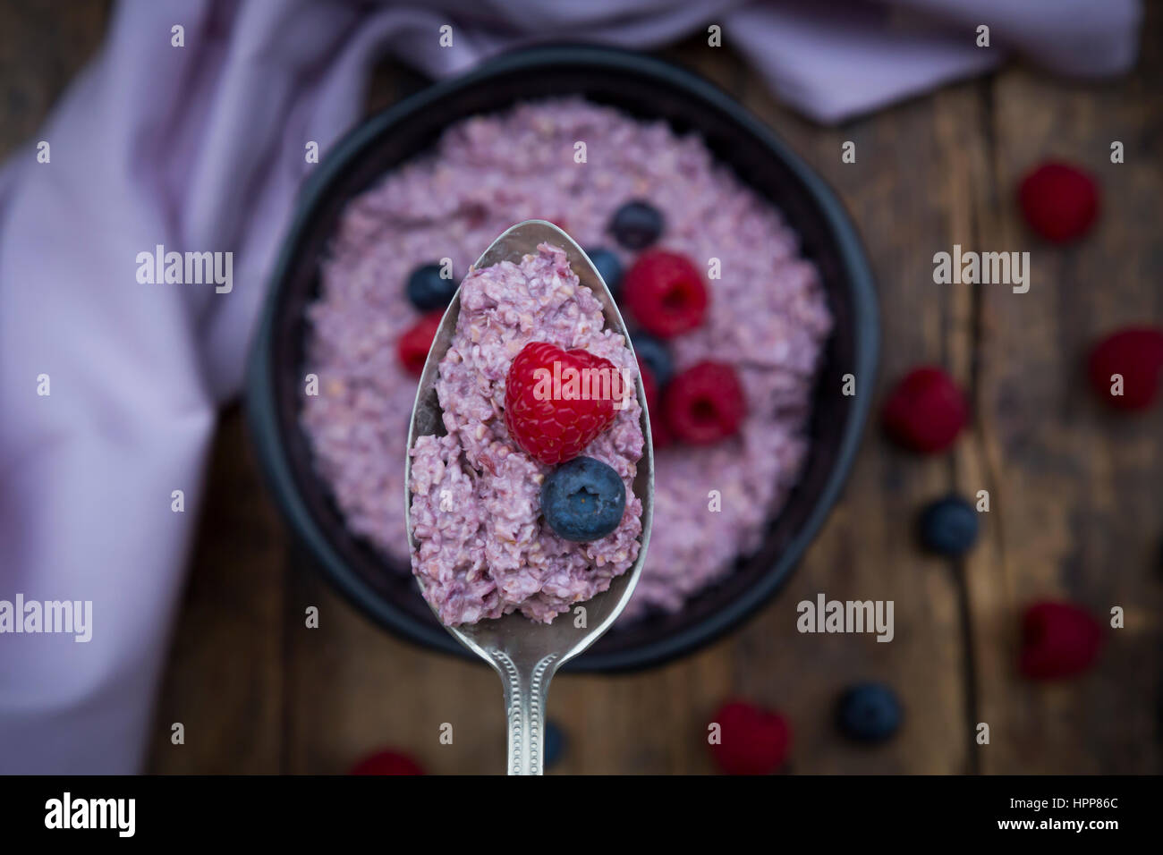 Spoon of overnight oats with blueberries and raspberries, close-up Stock Photo