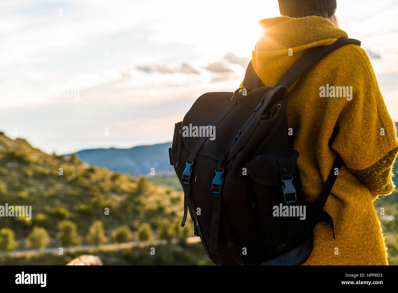 Young woman with backpack in nature at sunset Stock Photo - Alamy