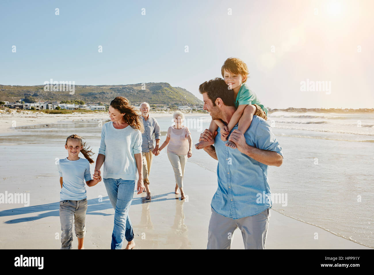 Three generations family strolling on the beach Stock Photo